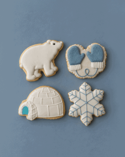 Biscuiți personalizați de Crăciun Artic: urs polar, iglu, mănuși albastre și fulg de zăpadă, pe fundal albastru.